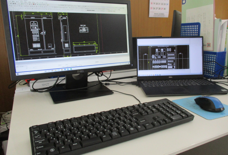 デスク上で2台のディスプレイを使って設計図を確認している様子